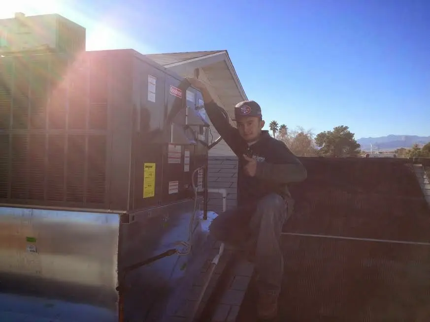 HVAC technician performing Air Duct Cleaning on a rooftop unit in Lafayette